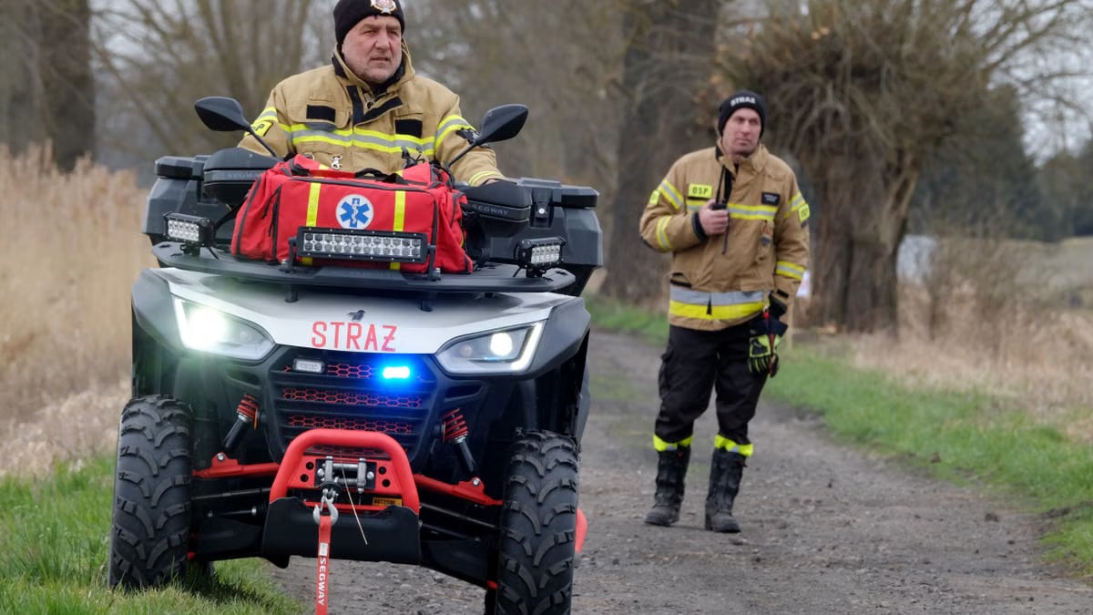 Firefighters patrol a rural area using a rescue ATV, showcasing readiness and emergency preparedness.
